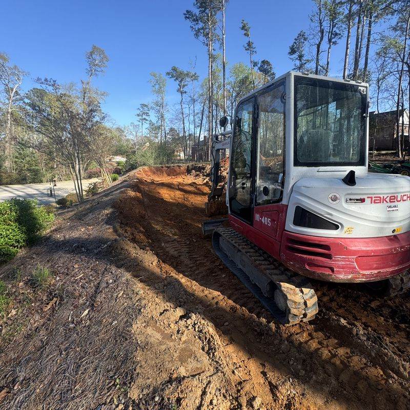 A compact excavator grading a yard in Martinez, GA